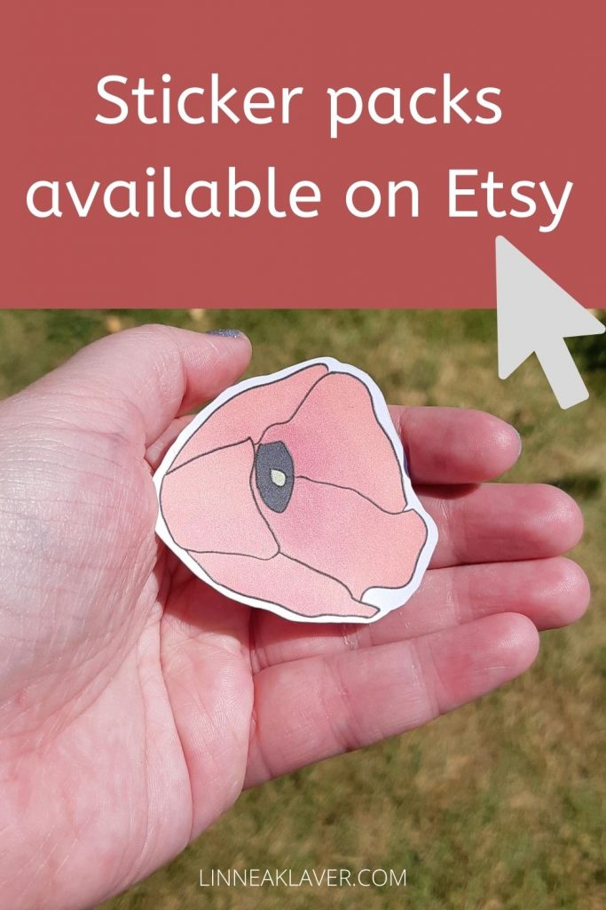 A die-cut poppy sticker cupped in the palm of a hand